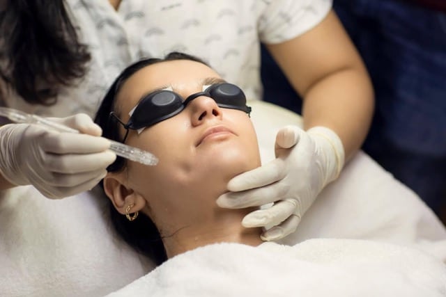 Young woman getting oxygen jet facial. Peeling procedure treatment at beauty salon or cosmetology center. Healthcare, wellness and beauty concept