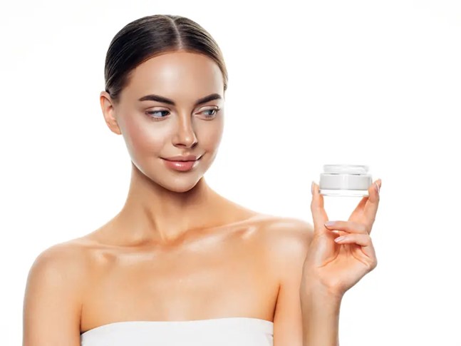 Young woman holding skin cream